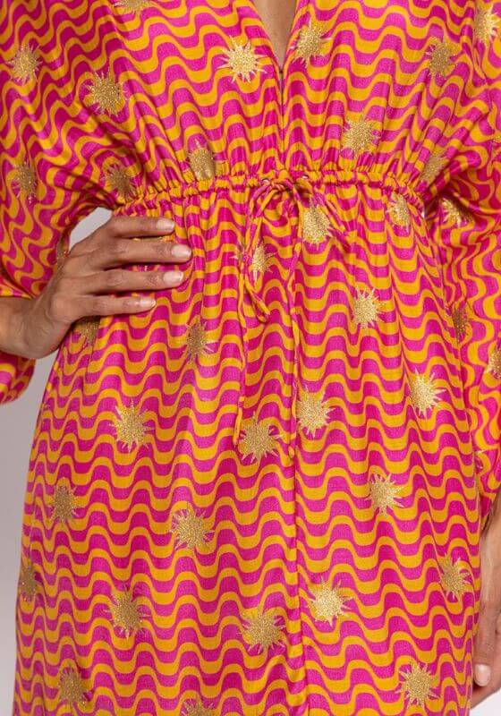 Sonia Arizona Dress by Sundress close-up of the fun orange and fuchsia spiral print with golden sun glitter.