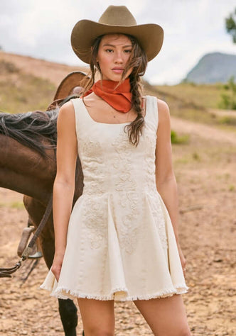 Kristen Sereia Dress by Agua Bendita on model, featuring structured bodice and pleated skirt with floral details.