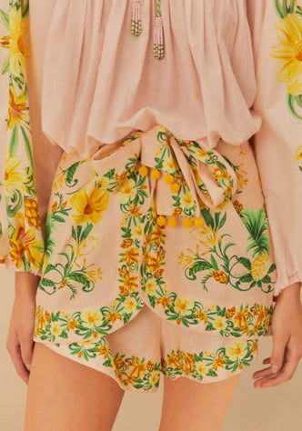 Pink Botanical Beauty Shorts by Farm Rio featuring vibrant floral patterns and playful tie design worn with a flowing blouse.