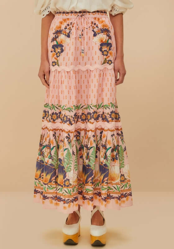 Pink Dream Garden Maxi Skirt by Farm Rio featuring vibrant floral patterns and flowing silhouette on soft pink fabric.