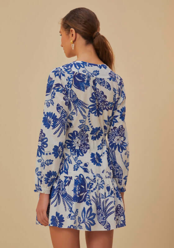 Flowerful Birds Mini Dress by Farm Rio, showcasing a blue floral pattern and long sleeves from a back view.