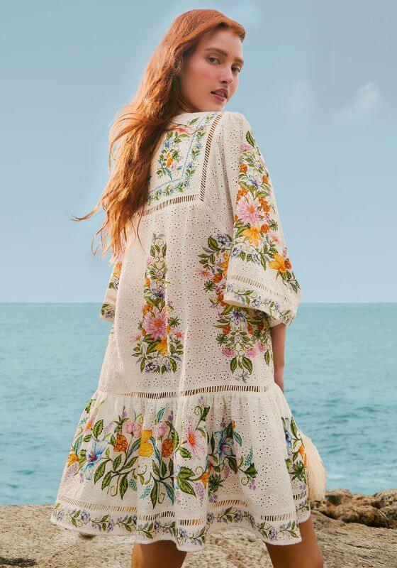 Sweet Bloom Bouquet Short Dress by Farm Rio, showcasing a model in a floral patterned cover-up near the ocean.