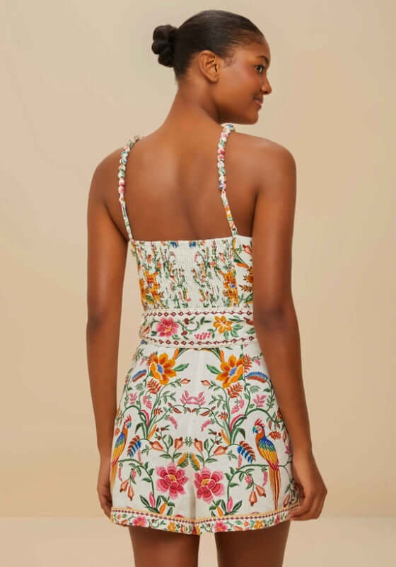 Delicate Forest Romper by Farm Rio, showcasing a model from the back, featuring vibrant floral prints and braided straps.