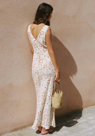 Keepsake Maxi Dress Sweet Pea by Peony, showcasing a woman from behind in a floral dress with crossed-back design.