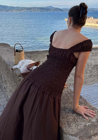 Sonnet Midi Dress Pecan by Peony, showcasing a smocked bodice and sweetheart neckline by the seaside.
