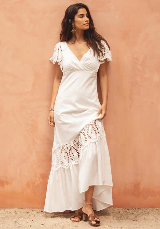 Copacabana Dress White by Sole Lisboa model wearing a V-neckline dress with eyelet details and peplum skirt.