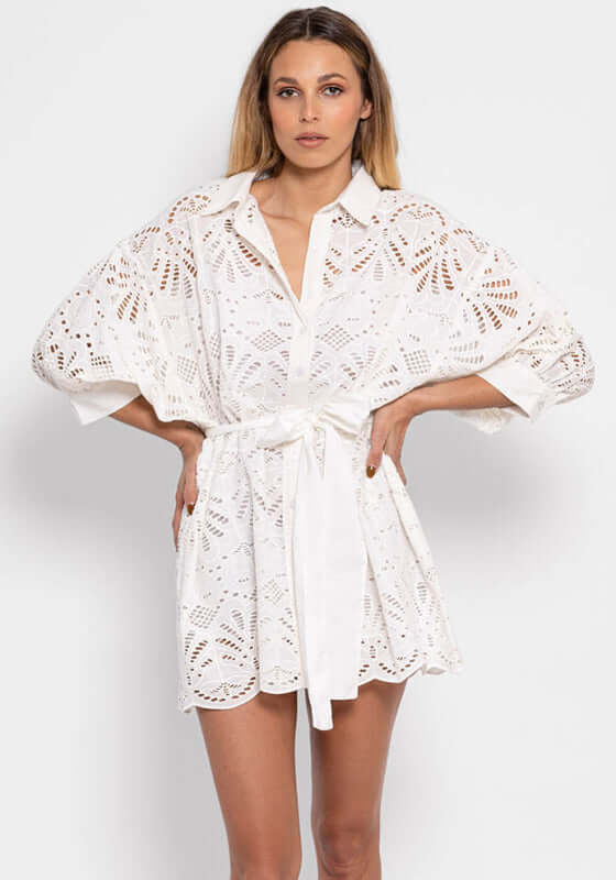 Florine Eyelet Dress by Sundress, a white short shirtdress with eyelet pattern and flared sleeves.