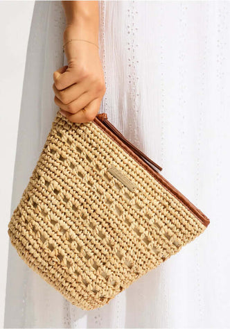 Savona Pouch by Seafolly, a stylish raffia pouch held by a hand, showcasing its zip opening and contrast binding.