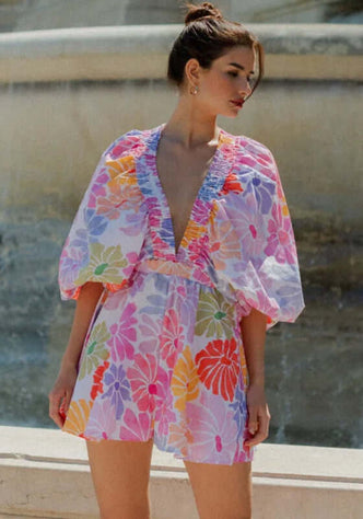 Alicia Jumpsuit Saleya Pastel by Sundress featuring kimono sleeves, V neckline, and floral pattern in pastel colors.