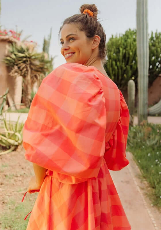 Alicia Jumpsuit Gingham Orange by Sundress, featuring vibrant gingham pattern and voluminous kimono sleeves.