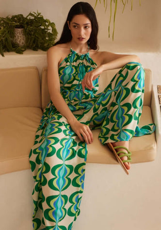 Sophie Jumpsuit Lullah by Sundress, featuring a relaxed fit with a striking green retro print and halter tie neckline.