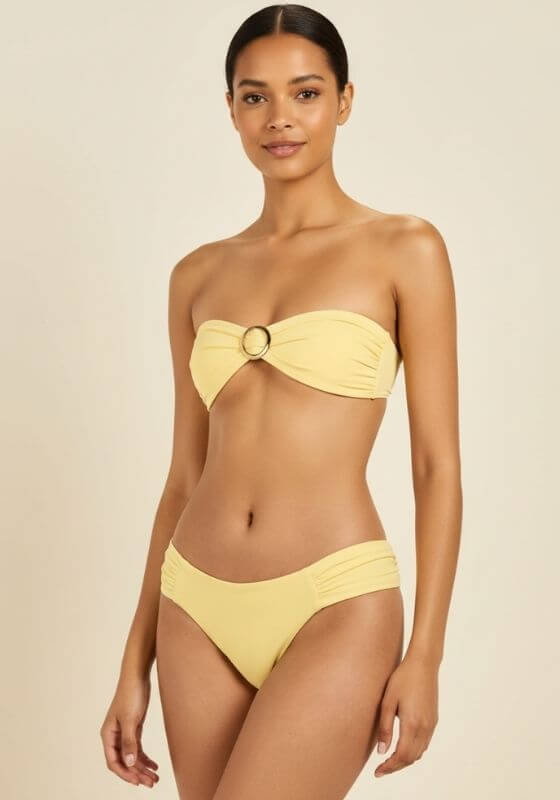 Buttercup Cayman Island Bikini by Away That Day, featuring a bandeau top with gold ring and ruched side bikini bottoms.