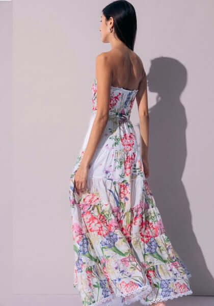 Danny Long Dress White Botanical by Charo Ruiz, showcasing a woman in a floral maxi dress with a fitted bodice.