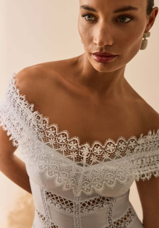 Amaira Dress White by Sole Lisboa, elegant off-shoulder neckline with delicate lace detailing.