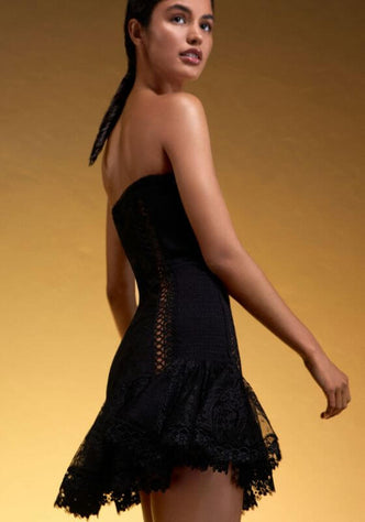 Victoire Dress Black by Charo Ruiz, showcasing a model in a flattering strapless design with ruffled lace.