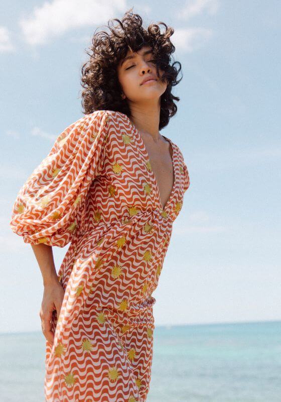 Evelyn Arizona Dress by Sundress, a flowy dress with V-neckline and flared sleeves in vibrant orange pattern.