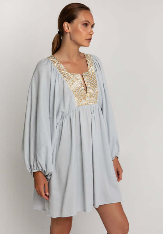 Triangle Long Sleeve Mini Dress Grey by Greek Archaic Kori; model wearing a light grey mini dress with gold embroidery.