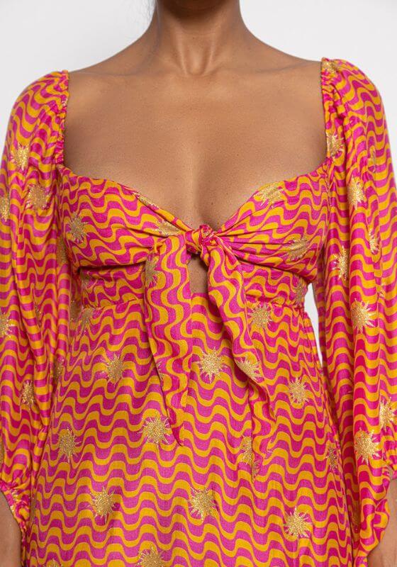 Ingrid Mini Dress Arizona by Sundress, featuring a bustier style with a knot, flared sleeves, and a vibrant fuchsia-orange print.