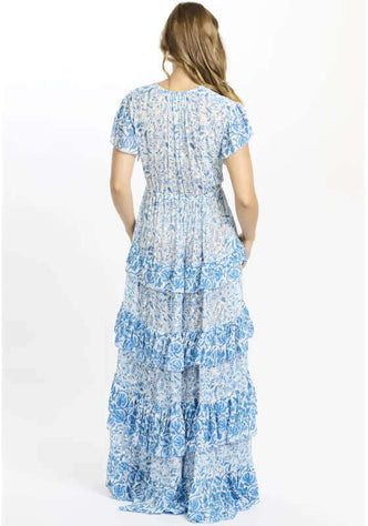 Celia Dress Blue by Miss June, showcasing the back of a tiered maxi dress with blue and white floral patterns.