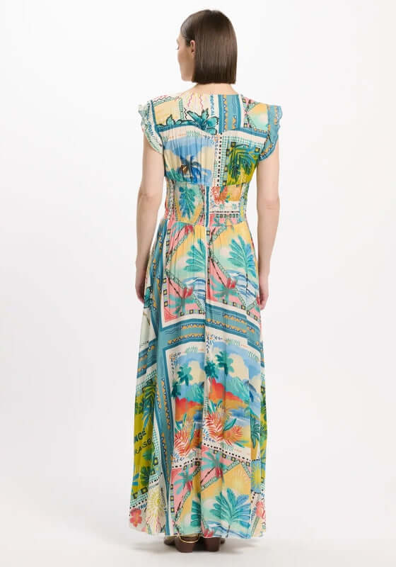 Taly Dress by Miss June, showcasing a vibrant postcard-style print with palm trees on soft blue fabric from the back.