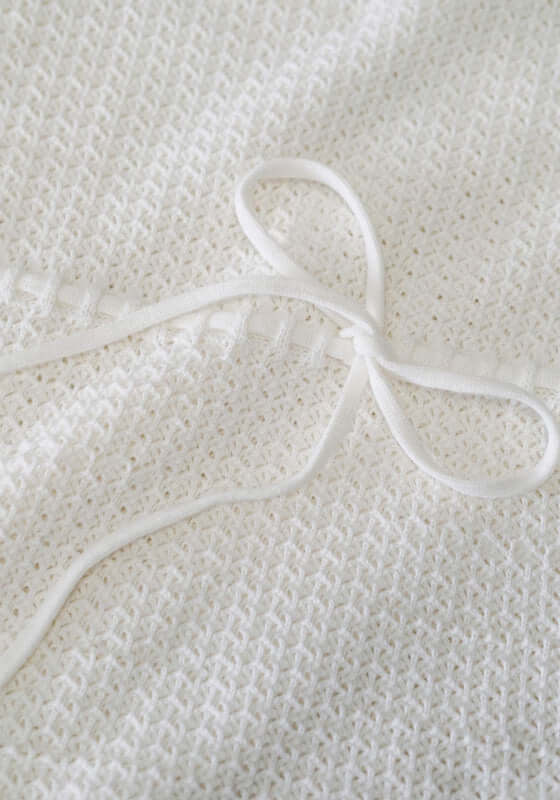 Pointelle Forever Maxi Dress by Peony close-up of crochet detailing and bow tie embellishment.