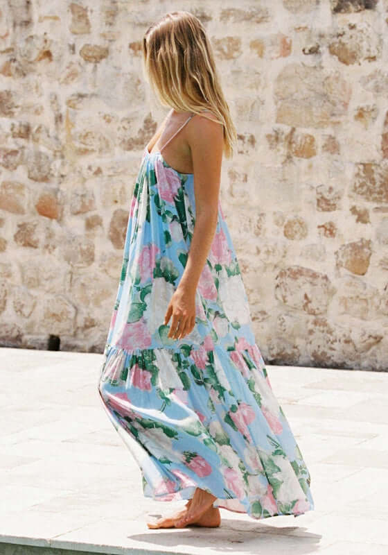 Enamour Gathered Maxi Dress by Peony, a model wearing a blue and pink floral maxi dress. Flowing and relaxed fit perfect for beachwear.