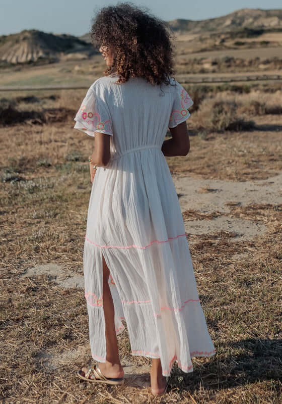 Holbox Long Dress Natural by Piti Cuiti, showing a woman in a flowing dress with embroidered details against a natural backdrop.