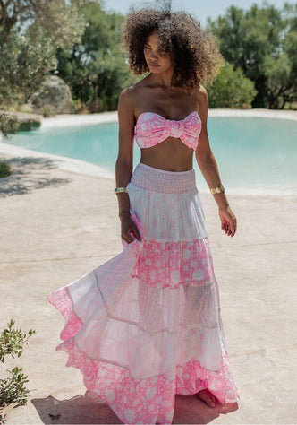 Amber Skirt White Pink by Piti Cuiti, a model wears a tiered skirt by the pool in soft white and pink tones.