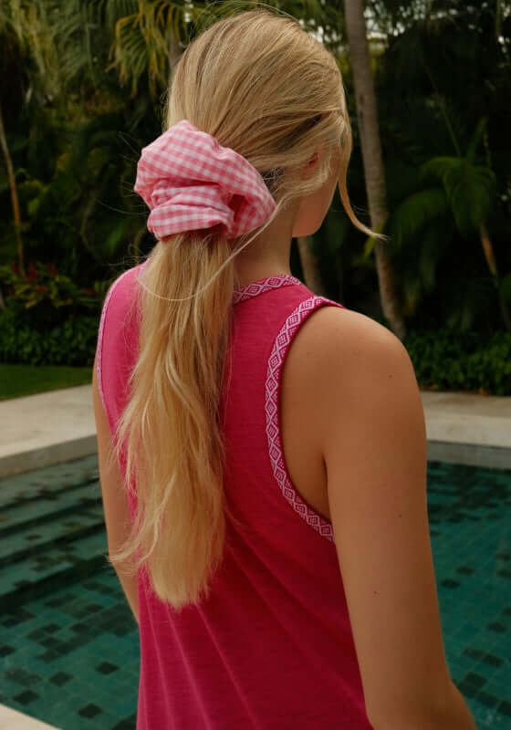 Tassel Slit Dress Fuchsia by Pitusa model wearing a pink scrunchie by the pool with long blonde hair.