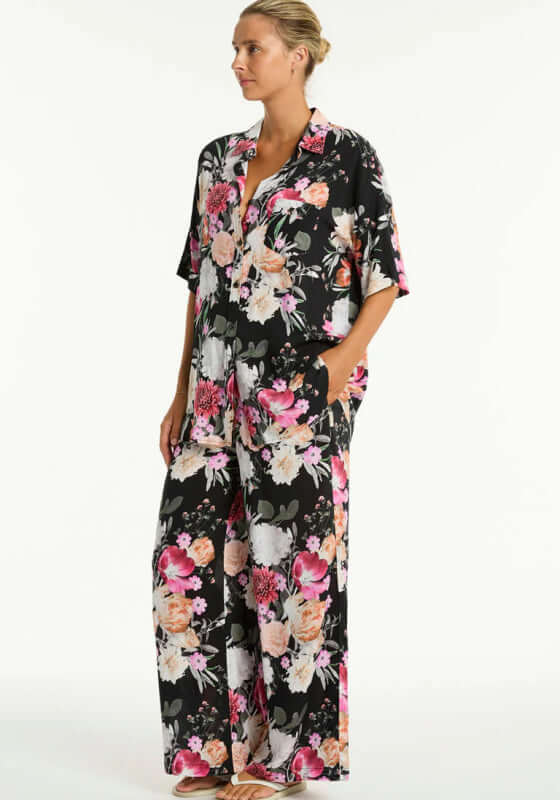 Chic Belle Aloha Beach Trousers in Black with floral print, featuring a drawstring waist and side pockets, perfect beach trousers.
