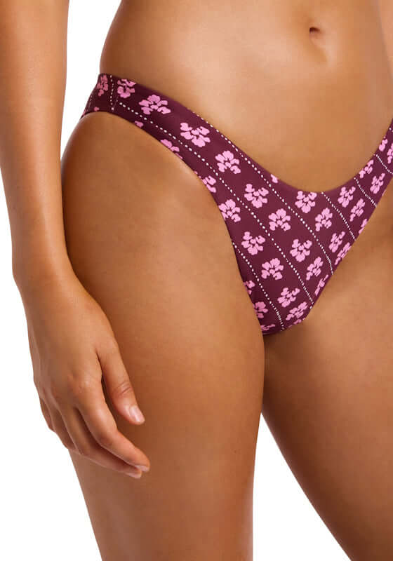 Batik Bloom High Cut Bikini Bottoms by Seafolly featuring a floral pattern in pink on a rich purple background.