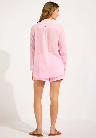 Breeze Beach Shirt Blossom by Seafolly, back view of a model wearing a pink beach shirt with button detailing and roll-up sleeves.