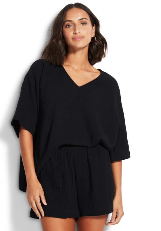 Model wearing black Double Cloth beach shorts and matching top, perfect for stylish summer beach outings.