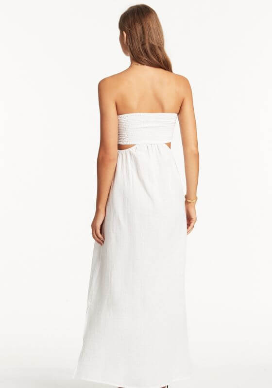 Sunset Bandeau Dress White by Sea Level worn by a model showing the back view with a shirred bust and long flowy design.