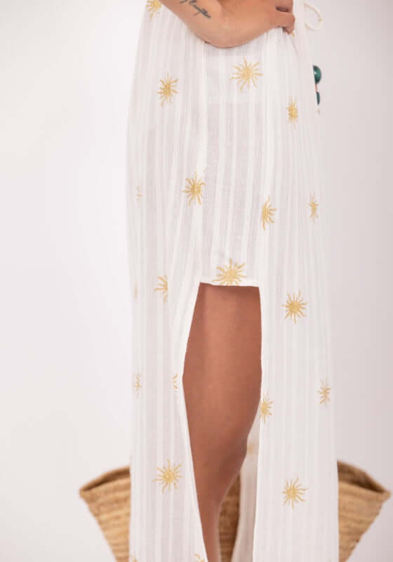Addy Kaftan White by Sundress, a flared caftan with pearl highlights and side slit for elegant movement.
