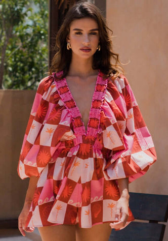 Alicia Jumpsuit Maritius by Sundress, featuring a V neckline, kimono sleeves, and flared bottom in vibrant print.