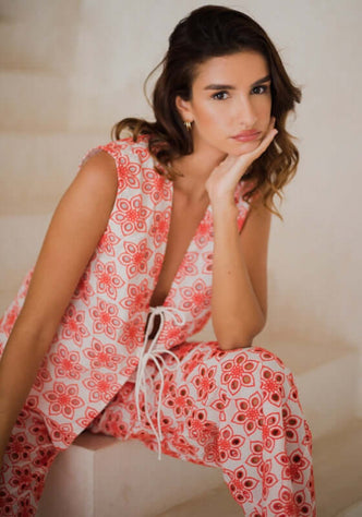 Bao Top Red Eyelet by Sundress worn by model, showcasing embroidered fabric and sleek spaghetti links.