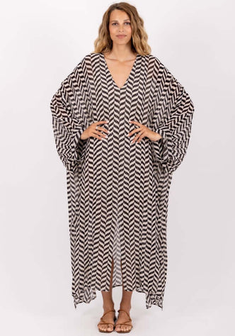 Louli Kaftan by Sundress featuring a striking black and white design, V neckline, and wide sleeves.