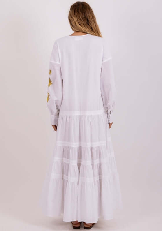 Nady Long Dress by Sundress. Back view of a model wearing a white gathered skirt dress with embroidered details.