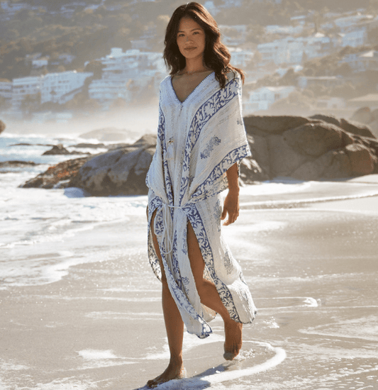Woman in a stylish kaftan on a beach, showcasing Discover Kaftan Trends for 2026 fashion.