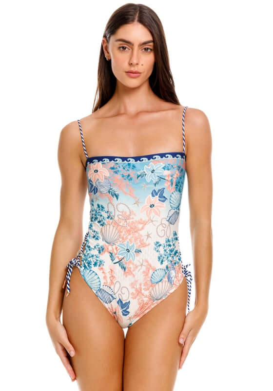 Mariel Sereia Swimsuit by Agua Bendita, showcasing a model in a floral print swimsuit with lace-up sides.