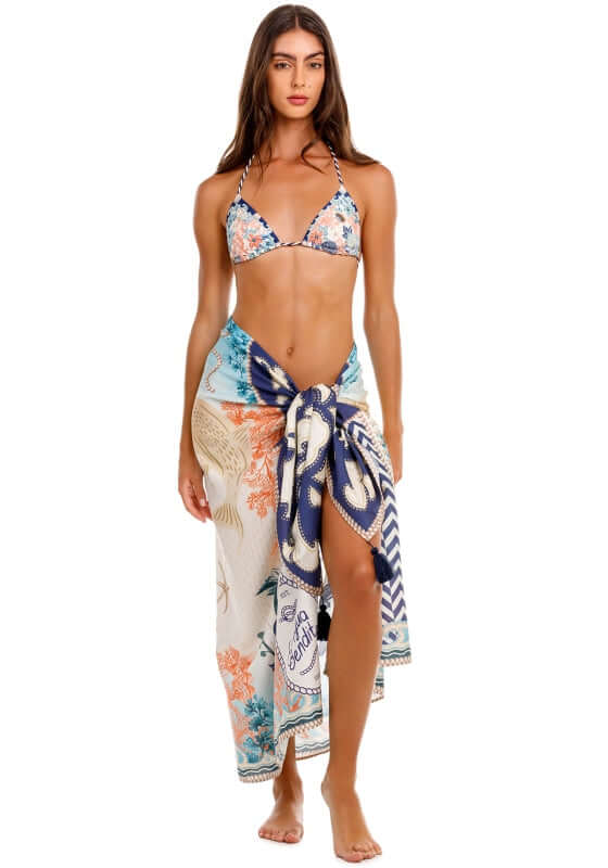 Marine Sereia Sarong by Agua Bendita, featuring coral reefs and seashells, worn stylishly with handmade tassels.
