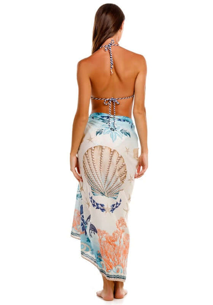 Marine Sereia Sarong by Agua Bendita, model showcases the back with coral reef print and handmade tassels.