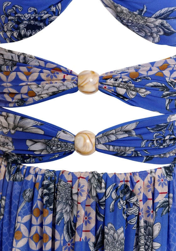 Meeg Quilt Maxi Dress by Agua Bendita close-up of bold cutouts with marble beads and floral patterns on blue fabric.