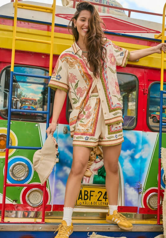Watts Fiore Beach Shorts by Agua Bendita model wearing coordinated beach outfit with vibrant prints and elastic waistband.