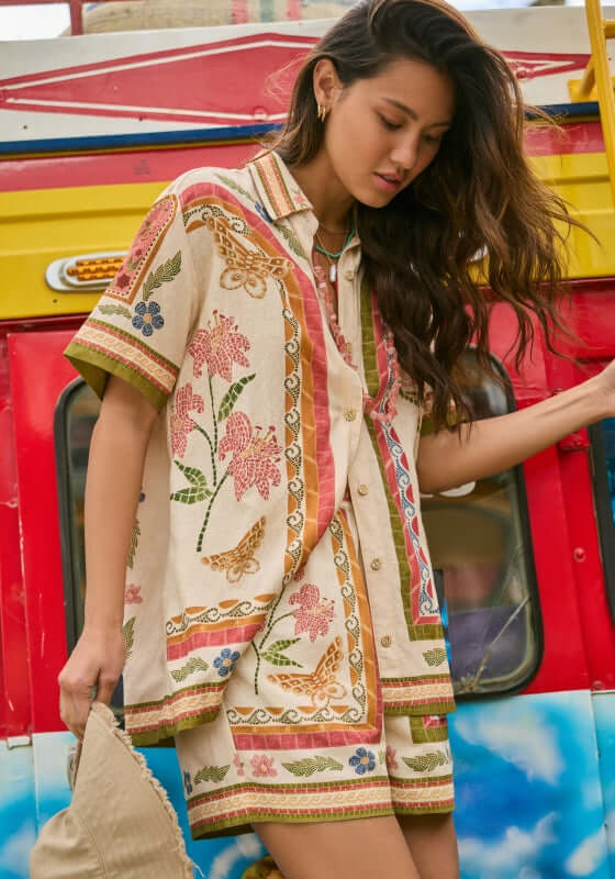 Ali Fiore Beach Shirt by Agua Bendita, woman wearing a stylish shirt with colorful floral print, relaxed fit.