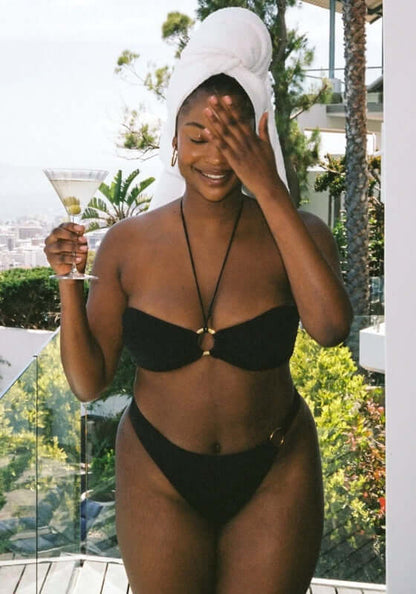 Acapulco Bikini Black by Away That Day, model wearing black bandeau bikini with elegant ring detail.