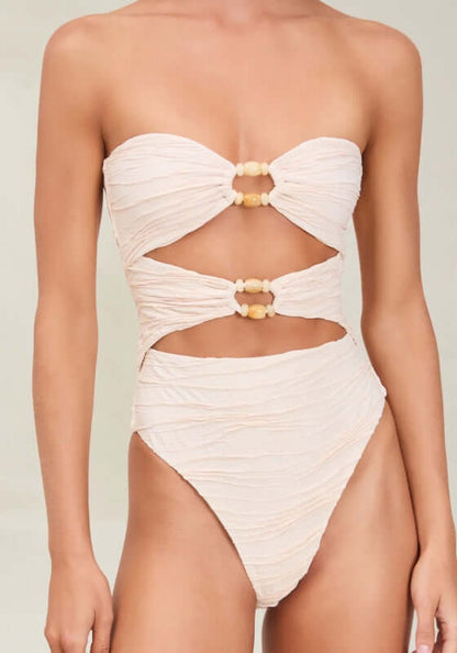 Amii Swimsuit Pebble by Devon Windsor features a flattering cut-out design and delicate beading in a soft cream tone.