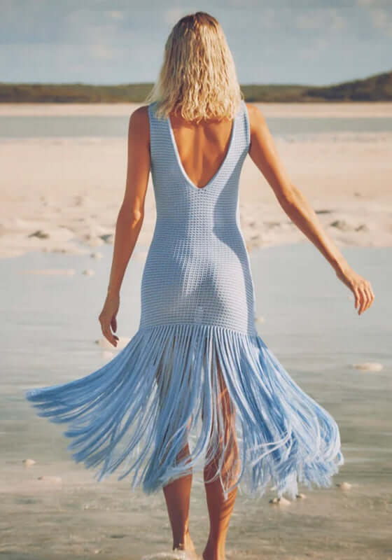 Leiza Dress Skylar by Devon Windsor showing a woman in a blue knit dress with flowing fringe at the beach.