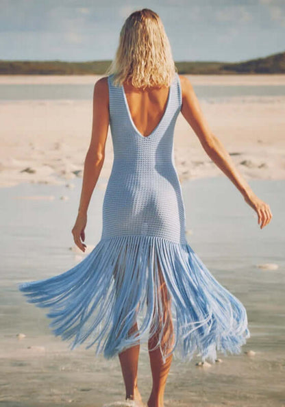 Leiza Dress Skylar by Devon Windsor showing a woman in a blue knit dress with flowing fringe at the beach.